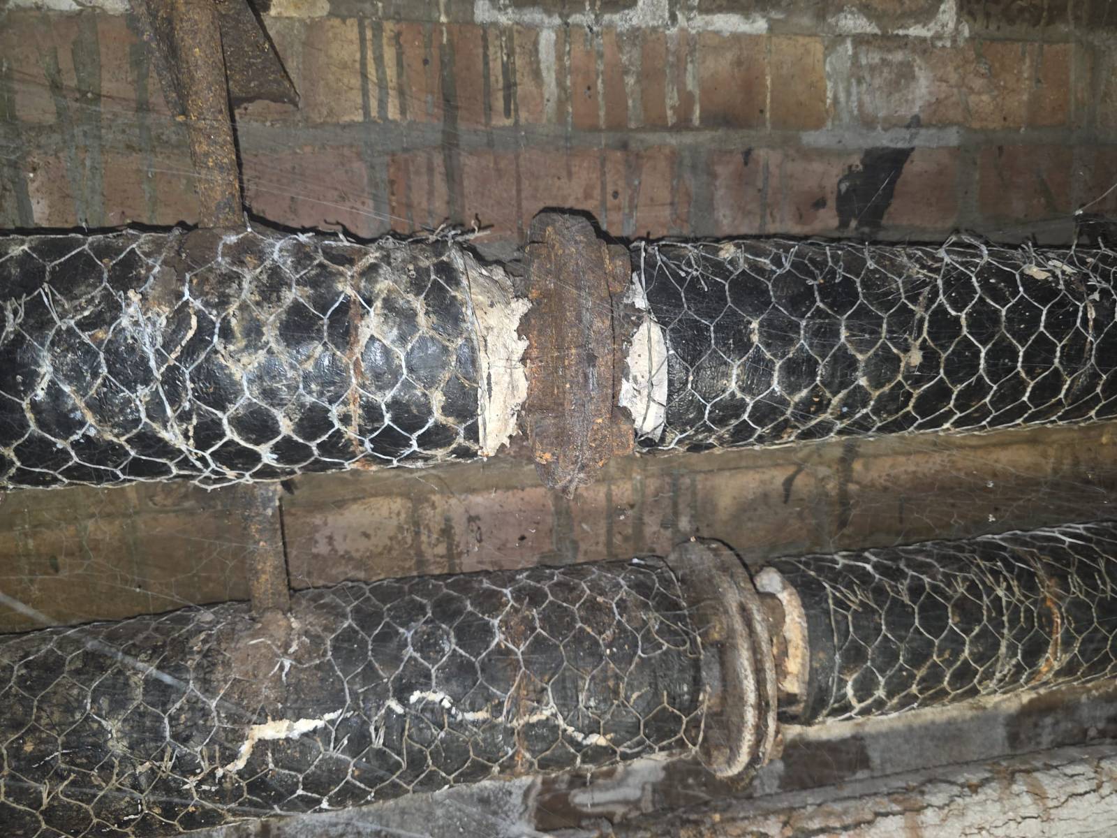 Cardinal Newman High School — asbestos pipe insulation in felt and wire-mesh wrap inside the duct before removal — Innov8 UK Group